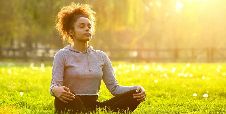 African American Woman Meditating In Nature.