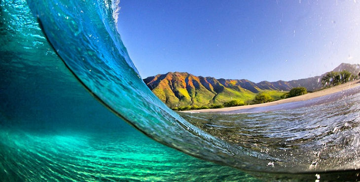 Image of a huge crystal clear wave with Na Pali coast in the background. Ho’oponopono-Self Healing from Life’s Mirrors