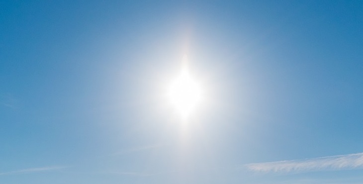 Image of the glowing Sun shining above the sky