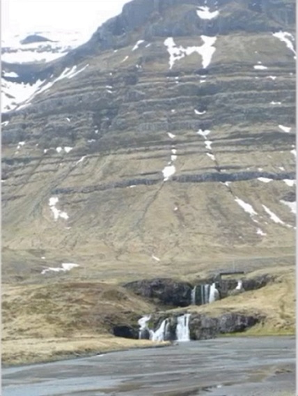 Image of a peaceful hillside and lovely waterfall from Iceland